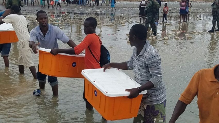 People in Haiti moving medical aid in a line