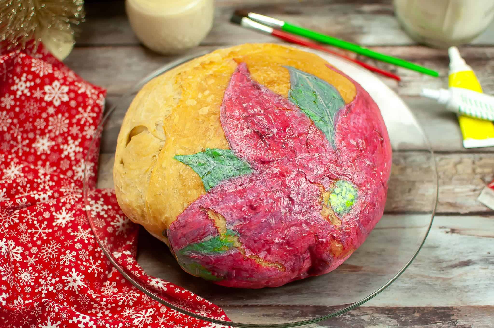 Side view of a poinsettia sourdough loaf painted on and baked