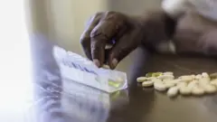 Mão com comprimidos