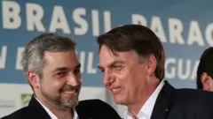 Mario Abdo Benitez e Jair Bolsonaro sorriem e conversam em evento