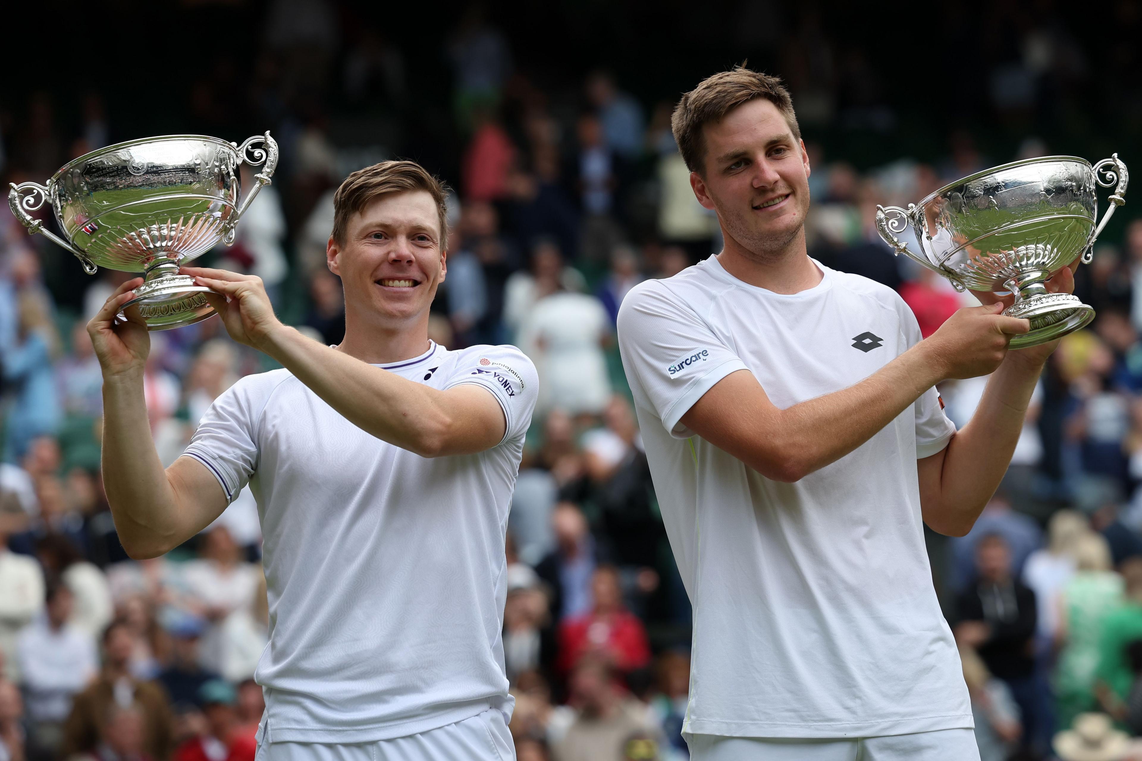 Harri Heliovaara and Henry Patten hold their Wimbledon doubles trophies