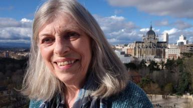 Valerie Stacey smiles from a rooftop terrace over Madrid