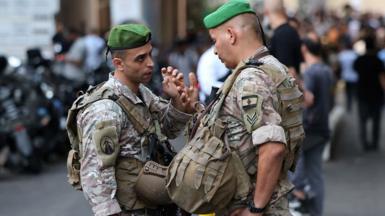 Two Lebanese soldiers face each other and talk intently