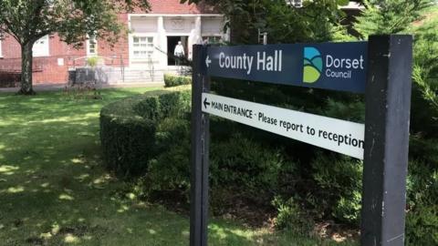 An image of a sign, which shows the directions to Dorset Council's county hall