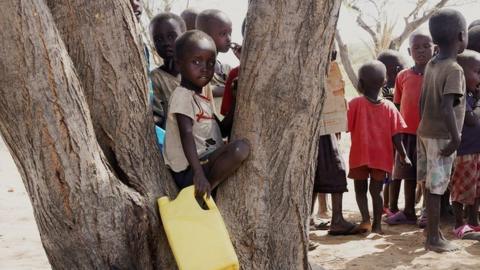 Children standing by a tree