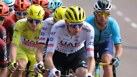 Mark Cavendish cycling next to Tadej Pogacar