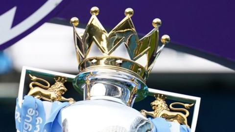 The Premier League trophy with Manchester City's ribbons on it