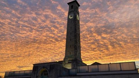 Southampton's Civic Centre clock with rippled gold and orange clouds behind