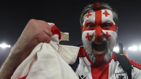 Georgia fan celebrates his team reaching Euro 2024