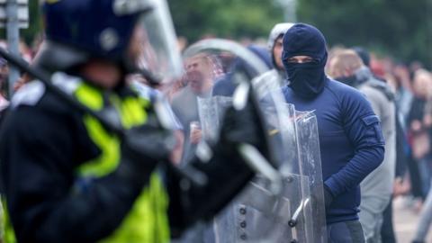 Riot police officers push back anti-migration protesters outside the Holiday Inn Express Hotel which is housing asylum seekers on August 4, 2024 in Rotherham, United Kingdom