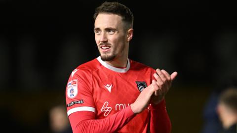 Toby Mullarkey of Grimsby Town applauds the fans