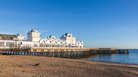 South Parade Pier, Southsea, Hampshire, southern England, UK, with stony pebble under a clear blue sky