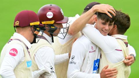 Archie Vaughan of Somerset CC celebrates the wicket of Dominic Sibley