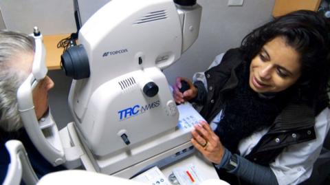 Medical worker performs eye scan