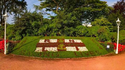 A flowerbed with a tribute to the RNLI to mark the charity's 200th anniversary in Jersey's Howard Davis Park. The design includes an RNLI flag made from red, white and green flowers and red plants spelling out 'thanks for saving lives' written around the sides.