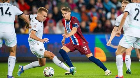 Martin Odegaard takes on some Austria players