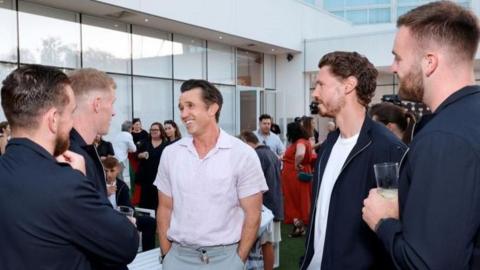 Wrexham owner Rob McElhenney talks to players at a red carpet event in Los Angeles