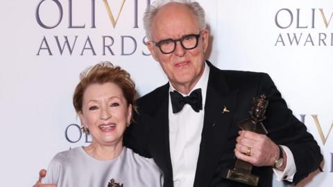 Lesley Manville, winner of the Best Actress award for "Oedipus", and John Lithgow, winner of the Best Actor award for "Giant", pose in the Winners Room at The Olivier Awards 2025 with Mastercard at The Royal Albert Hall on April 6, 2025 in London, England