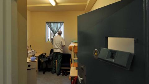 Inmate stands by window in cell of UK prison (file picture)