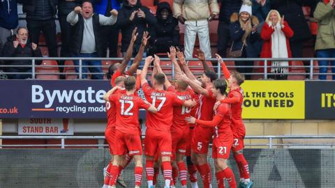 Leyton Orient players celebrate Omar Beckles' goal against Crawley in front of the home fans 