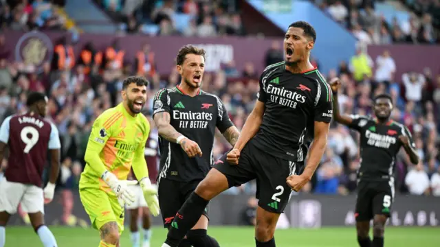 William Saliba of Arsenal celebrates, after Thomas Partey of Arsenal (not pictured) scores his team's first goal during the Premier League match between Aston Villa FC and Arsenal FC at Villa Park