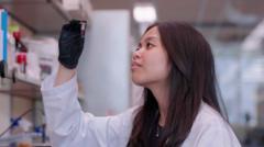 Denise Catacutan em laboratório segurando tubo de ensaio