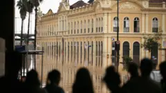 Moradores de Porto Alegre observam Mercado Público inundado, em foto de 4 de maio