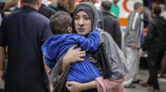 Una mujer lleva a un niño en los brazos en Gaza