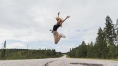 Mulher jovem saltando de felicidade na Finlândia