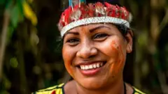 Mulher indígena sorrindo em foto tirada em clos