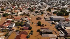 Vista de drone mostra barco com voluntários em busca de pessoas isoladas em casas no bairro de Mathias Velho, em Canoas, Rio Grande do Sul