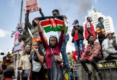Grupo de jovens estudantes manifestantes quenianos segurando bandeira
