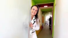 Empresária abre porta de sua empresa sorrindo para a câmera