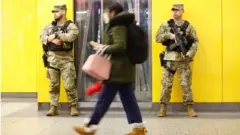 Membros da Guarda Nacional patrulham a Penn Station, Nova York