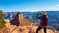 Mulher de costas tirando foto no Grand Canyon