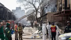 Bombeiros em frente ao prédio incendiado