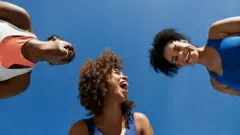 Fotografia de três mulheres negras rindo juntas