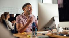 Funcionário sorrindo em frente ao computador no escritório