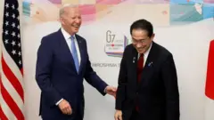 Primeiro-ministro do Japão, Fumio Kishida, cumprimenta o presidente dos EUA, Biden, em Hiroshima