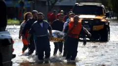 Socorristas carregam uma pessoa em maca em Porto Alegre