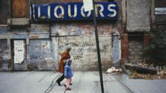Mulher passeia com uma menina no Harlem, um dos bairros mais pobres de Nova York