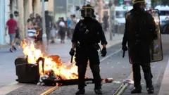 Policiais olham incêndio na rua