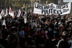 Pessoas carregam faixa em manifestação com o texto "Libertad a lxs presxs políticxs" 