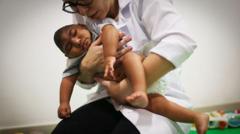 Médica faz fisioterapia em bebê com microcefalia