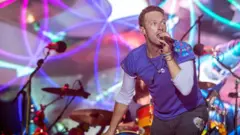 Chris Martin cantando no festival Glastonbury