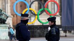 Policiais em frente a símbolo com arcos olímpicos