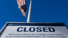 Placa embaixo de bandeira dos EUA com aviso: 'Closed' (fechado)