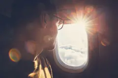 Homem olhando através de janela de avião 