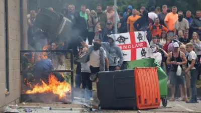 Manifestantes jogam uma lata de lixo durante um protesto anti-imigração, em Rotherham, Grã-Bretanha