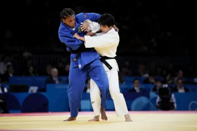 Duas judocas duelam no tatame